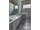 A beautifully designed bathroom with marble tile, a large mirror, and a modern shower with glass doors at 24803 Buckingham Way, Port Charlotte, FL 33980