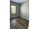 Bright bedroom features wood floors and a sun-filled window at 24803 Buckingham Way, Port Charlotte, FL 33980