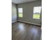A cozy bedroom with two sunny windows, hardwood floors, and neutral walls for a bright, airy feel at 24803 Buckingham Way, Port Charlotte, FL 33980