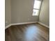 A bedroom with hardwood floors, a small window, and neutral walls for a simple, clean look at 24803 Buckingham Way, Port Charlotte, FL 33980