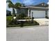 A well-maintained, one-story home with a two-car garage and a manicured lawn, under a partly cloudy sky at 24803 Buckingham Way, Port Charlotte, FL 33980