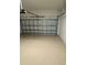 View of garage with speckled epoxy floor and sectional overhead door at 24803 Buckingham Way, Port Charlotte, FL 33980