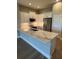 Modern kitchen with white cabinets, stainless steel appliances, and a spacious quartz countertop island at 24803 Buckingham Way, Port Charlotte, FL 33980