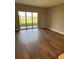 The living room boasts sleek hardwood floors and a glass sliding door that provide ample natural light at 24803 Buckingham Way, Port Charlotte, FL 33980