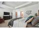 Bright bedroom with natural light boasts a king bed, mounted TV, and a cozy seating area at 2500 Boone Ct, Sarasota, FL 34237