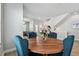 Dining room with a round wood table, blue chairs, and wood flooring at 2500 Boone Ct, Sarasota, FL 34237