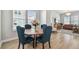 Bright dining area featuring a round table with blue upholstered chairs, wood flooring, and bright light at 2500 Boone Ct, Sarasota, FL 34237