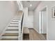 Bright entryway featuring a staircase with modern railing and light wood floors and a hallway bench with storage at 2500 Boone Ct, Sarasota, FL 34237
