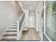 Bright entryway featuring a staircase with modern railing and light wood floors and a hallway bench with storage at 2500 Boone Ct, Sarasota, FL 34237