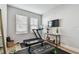 Bright home gym with work out equipment and two windows with white blinds at 2500 Boone Ct, Sarasota, FL 34237