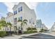 Charming two-story townhome features a white exterior, balcony, and a fenced-in patio with lush landscaping at 2500 Boone Ct, Sarasota, FL 34237
