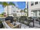 Well-maintained exterior with a cozy patio, grill, and views of other townhome garages at 2500 Boone Ct, Sarasota, FL 34237