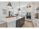 Modern kitchen with white cabinets, stainless steel appliances, and a large center island at 2500 Boone Ct, Sarasota, FL 34237
