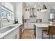 Modern kitchen with stainless steel appliances, island with seating, white cabinets and a kitchen sink with view at 2500 Boone Ct, Sarasota, FL 34237