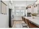 Bright kitchen features white cabinets, marble backsplash, stainless steel appliances, and a center island with bar stools at 2500 Boone Ct, Sarasota, FL 34237