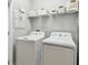Well-equipped laundry room with washer, dryer, and overhead storage shelving at 2500 Boone Ct, Sarasota, FL 34237