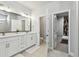 Modern main bathroom with dual sinks, white cabinetry, and walk-in closets at 2500 Boone Ct, Sarasota, FL 34237