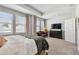 Sunlit main bedroom boasts tray ceilings, a cozy chair and a large television at 2500 Boone Ct, Sarasota, FL 34237