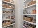 Walk-in pantry with open shelving, filled with baskets, food, and cookbooks at 2500 Boone Ct, Sarasota, FL 34237