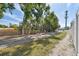 A street view near the property shows lush greenery, a wooden fence and glimpses of houses at 2500 Boone Ct, Sarasota, FL 34237