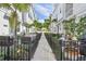 Beautiful townhome alley featuring black metal fences, lush greenery, and outdoor furniture at 2500 Boone Ct, Sarasota, FL 34237