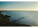 Scenic aerial view of a pier extending into the water, bordered by lush greenery against a clear sky at 2511 Lantana Ln, Palmetto, FL 34221