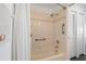 Bathroom shower with tile surround, grab bars, and white shower curtain at 2511 Lantana Ln, Palmetto, FL 34221