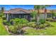 Beautiful home exterior featuring a screened lanai and a lush, landscaped backyard with palm trees at 2525 Daisy Dr, North Port, FL 34289