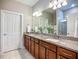 This bathroom shows a double vanity with granite countertop, updated vanity lights, and a tiled walk-in shower at 2525 Daisy Dr, North Port, FL 34289
