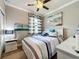 Cozy bedroom featuring stylish nautical decor, a ceiling fan, a neutral paint palette, and a large window at 2525 Daisy Dr, North Port, FL 34289