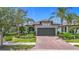 Charming home featuring a well-manicured lawn, a brick driveway, and mature palm trees at 2525 Daisy Dr, North Port, FL 34289