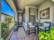 Inviting front porch featuring neutral decor, comfortable seating, and attractive plants at 2525 Daisy Dr, North Port, FL 34289