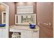 Bathroom featuring a marble countertop, white cabinets, and a unique blue glass bowl sink at 25433 Colon Dr, Punta Gorda, FL 33983