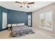 Cozy bedroom with a blue accent wall, plantation shutters, and soft carpeting for a comfortable retreat at 25433 Colon Dr, Punta Gorda, FL 33983
