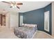 Comfortable bedroom featuring a navy accent wall, neutral carpeting, and plantation shutters for natural light at 25433 Colon Dr, Punta Gorda, FL 33983