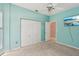 Bedroom features light blue walls, closet, ceiling fan, and a wall-mounted tv at 25433 Colon Dr, Punta Gorda, FL 33983