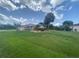 Spacious home with a red tile roof surrounded by a lush green lawn and mature trees on a sunny day at 25433 Colon Dr, Punta Gorda, FL 33983