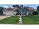 Inviting home boasts a red tile roof, manicured lawn, and decorative seahorse mailbox in a lush landscape at 25433 Colon Dr, Punta Gorda, FL 33983