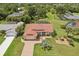 Aerial view of a beautiful single-Gathering home with a red tile roof, lush landscaping, and an inviting brick driveway at 25433 Colon Dr, Punta Gorda, FL 33983