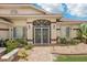 Inviting home entrance featuring a decorative security door and well-maintained, colorful landscaping at 25433 Colon Dr, Punta Gorda, FL 33983