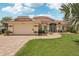 Charming single-story home features a red tile roof, lush landscaping, and a brick paver walkway and driveway at 25433 Colon Dr, Punta Gorda, FL 33983
