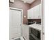 Laundry room with modern appliances, white cabinets, and neutral paint at 25433 Colon Dr, Punta Gorda, FL 33983