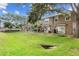 View of the green backyard with a retaining wall behind townhomes at 2553 Harn Blvd # 1, Clearwater, FL 33764