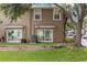 Townhome exterior with grass backyard and a retaining wall at 2553 Harn Blvd # 1, Clearwater, FL 33764