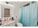 Bright bathroom featuring a vanity with an illuminated mirror, toilet, and shower with blue curtain at 2553 Harn Blvd # 1, Clearwater, FL 33764