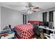 Bedroom with ceiling fan, red bedspread, desk, computer and gaming chair at 2553 Harn Blvd # 1, Clearwater, FL 33764