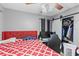 Bedroom featuring ceiling fan, red bedspread, and closet with sliding barn door at 2553 Harn Blvd # 1, Clearwater, FL 33764