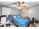 Bedroom with ceiling fan, blue patterned bedspread, desk, and computer at 2553 Harn Blvd # 1, Clearwater, FL 33764