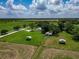 Aerial view of large property with outbuildings, mature trees, paddocks and pond at 26147 L And J Rd, Myakka City, FL 34251