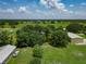 Expansive property with a serene pond, mature trees, lush greenery, and multiple structures at 26147 L And J Rd, Myakka City, FL 34251
